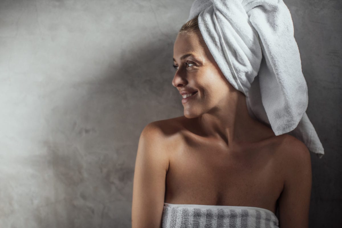 Жена после душа обматывает себя полотенцем фото